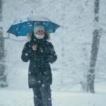 Dogodki v Ljubljani. Na fotografiji oseba z dežnikom v snežnem metežu.